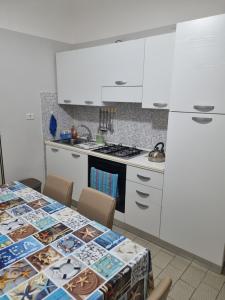 a kitchen with a table and a stove and white cabinets at Risorgimento House in Catania