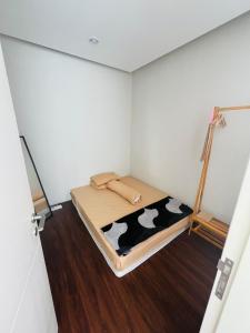a small room with a bed with a cow blanket at Embun Pagi villa - Habitat 110 in Batu +4 photos