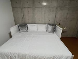 a white bed with pillows on it in a room at Sunshine in Tokyo