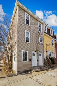 a gray house with white doors on a street at Queens Suite 1bdrm in St. John's