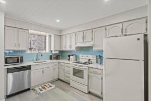 a kitchen with white cabinets and a white refrigerator at Jersey Shore Getaway in Seaside Heights