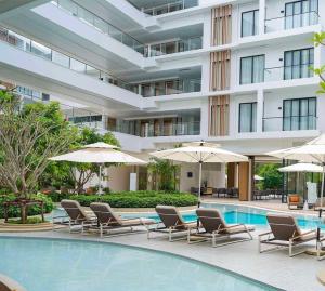 a hotel pool with lounge chairs and umbrellas at Laya Residence Memoory Layan in Ban Na Bon