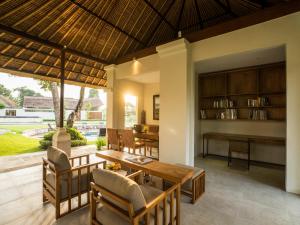 a dining room with a table and chairs and a library at The Samata by LifestyleRetreats in Sanur