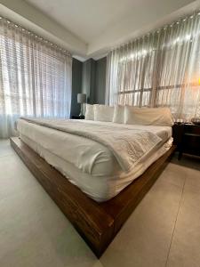 a large bed in a bedroom with windows at Beachfront Collins Rentals in Miami Beach