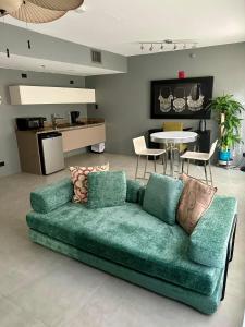 a green couch in a living room with a table at Beachfront Collins Rentals in Miami Beach