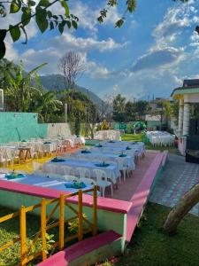 a group of tables with white tables and chairs at Hotel Minnesota y Centro de Eventos Molina in San Lucas Tolimán