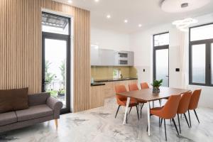 a kitchen and dining room with a table and chairs at DELUXE VILLA 2 có 5 phòng ngủ trung tâm tp in Thôn Trường Giang