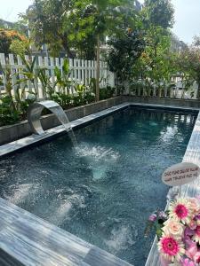 a swimming pool with a water fountain in it at DELUXE VILLA 2 có 5 phòng ngủ trung tâm tp in Thôn Trường Giang