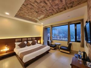 a bedroom with a bed and a large window at The White Orchid Dalhousie in Dalhousie