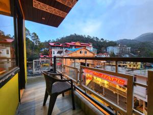 a balcony with a chair and a view of a city at The White Orchid Dalhousie in Dalhousie