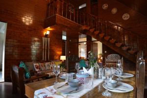 una sala da pranzo con un tavolo con bicchieri da vino di Rosette Cottage by EdenHomes a Manāli