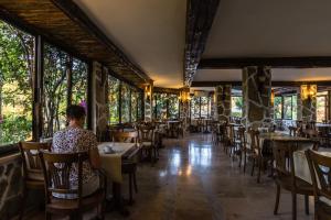 una persona sentada en una mesa en un restaurante en Pataros Hotel, en Patara