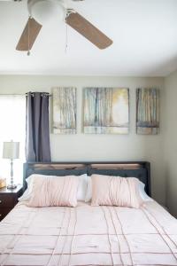 a bed with two pillows and a ceiling fan at Historic, Family-Friendly Home in Downtown in Bakersfield