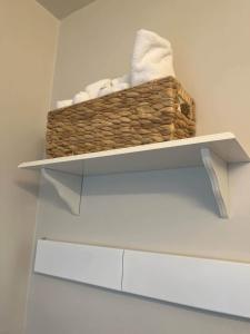 a basket of towels on a shelf in a bathroom at Historic, Family-Friendly Home in Downtown in Bakersfield
