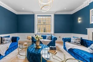 a living room with blue walls and blue couches at Baths Ultimate House Sleeps 40 in Bath