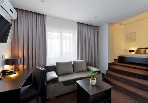 ein Hotelzimmer mit einem Sofa und einem Bett in der Unterkunft Hotel Capitol in Biała Podlaska