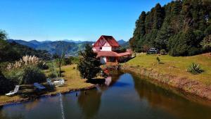 a house sitting on the side of a river at Loft 1 Sitio Cachoeiras do Caledônia in Nova Friburgo