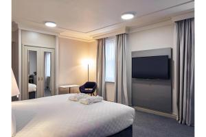 a hotel room with a bed and a flat screen tv at Exeter Rougemont Station Experience By Palette Resorts in Exeter