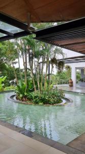 Un estanque de agua con árboles en un edificio. en Cozy apartment Karon, en Phuket