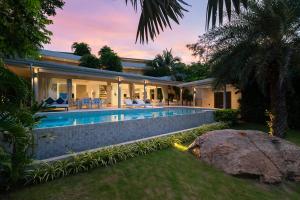 an exterior view of a house with a swimming pool at Villa Maliya in Plai Laem