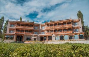a large pink building with a lot of windows at Hotel Zomday in Leh