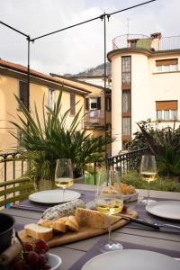 a table with glasses of wine and bread on a balcony at La casa sulla Terrazza in Sarnico