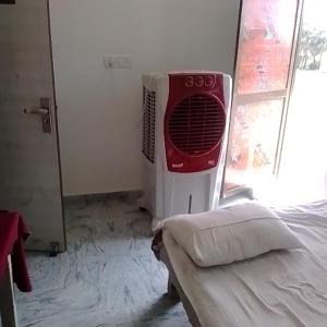 Sujata Buddha Homestay في بود جايا: غرفة بها سرير ومروحة بجوار نافذة