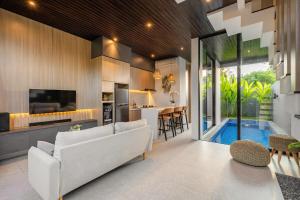 ein Wohnzimmer mit einer weißen Couch und einer Küche in der Unterkunft Private Villa Ayra 8D by OriVista 10min to Melasti Beach in Uluwatu