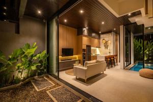 ein Wohnzimmer mit Couch und Küche in der Unterkunft Private Villa Ayra 8D by OriVista 10min to Melasti Beach in Uluwatu