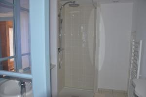 a shower with a glass door next to a sink at Villa Lea in Toulouse