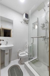 a bathroom with a toilet and a sink and a shower at LOUIS Apartment in Ikota