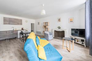 a living room with a blue couch and a kitchen at La Perle de Pau in Pau