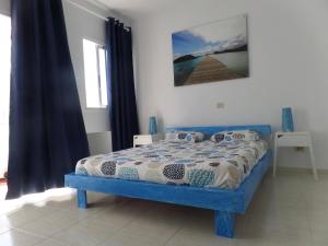 a bedroom with a blue bed in a room at The Inn in Corralejo