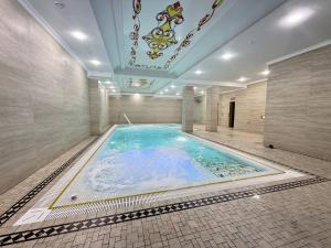 a large swimming pool in a building with a ceiling at Ko'k Saroy Plaza Hotel in Samarkand