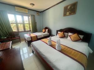 Postel nebo postele na pokoji v ubytování Khampaseuth Hotel