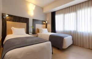 a hotel room with a large bed and a large window at Hotel Alif Avenidas in Lisbon