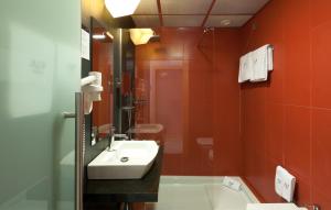 a bathroom with a sink, toilet and mirror at Hotel Alif Avenidas in Lisbon