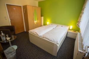 ブラウンラーゲにあるMemory Hotelの緑の壁と大きなベッドのある寝室