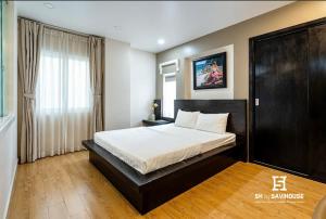 a bedroom with a bed and a large window at SaiGon Huch Villa in Ho Chi Minh City