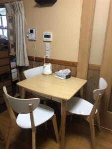 a wooden table with two chairs and a table and a lamp at Nara House R1 in Kawagoe