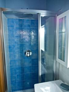 a blue tiled bathroom with a shower and a sink at B&B I Girasoli in Francavilla al Mare