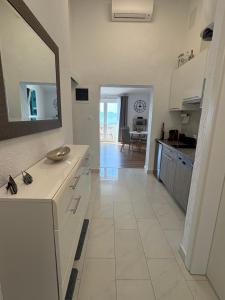 a white kitchen with a sink and a mirror at Apartment4you in Senj +47 photos