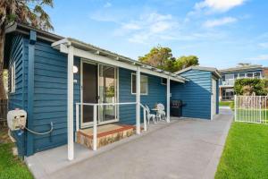a blue house with a porch at Surfrider Studio - Pet Friendly - 50m to Beach! in Culburra Beach +6 photos