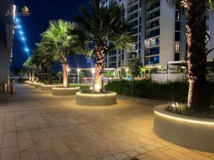 una hilera de palmeras en una acera por la noche en Modern Sunset View 2Bhk 6pax, en Dubái