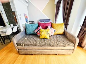 a couch with colorful pillows on it in a living room at Grand Horizon Imperium Residence Kuantan Studio City view in Kuantan +52 photos