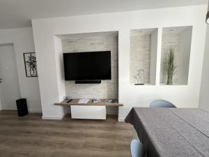 a living room with a flat screen tv on a wall at MARY Apartment in Tarvisio