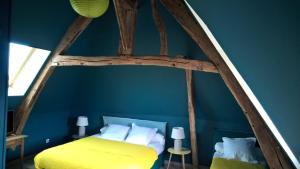 a bedroom with a bed in a blue wall at Le Saint Aubin- Maison d hôtes dans ce monastère du 16 siècle in Amfreville-la-Campagne