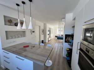 a white kitchen with a dining table and a television at MARY Apartment in Tarvisio
