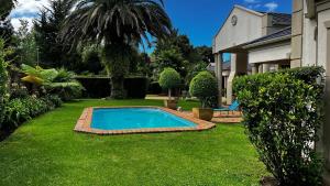 a swimming pool in the yard of a house at Plovers Rest in George