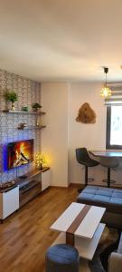 Una sala de estar con chimenea y una mesa. en Stars Apartman Jahorina, en Jahorina